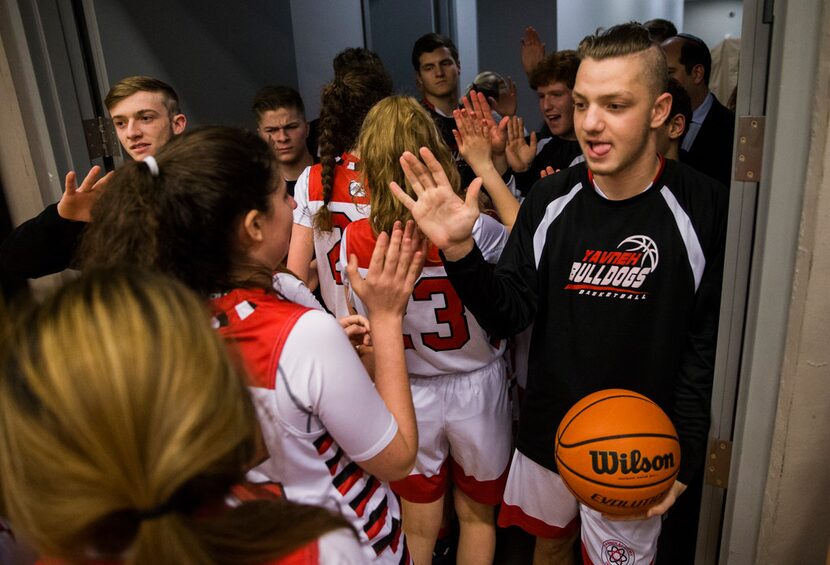 Yavneh boys basketball players high-five girls basketball players before their playoff game...