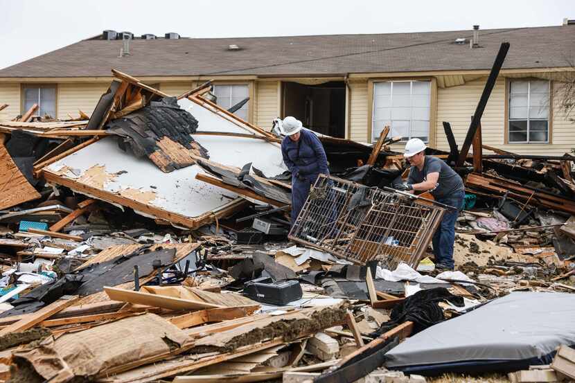 Dallas Fire-Rescue workers continue to investigate and remove debris from an apartment...