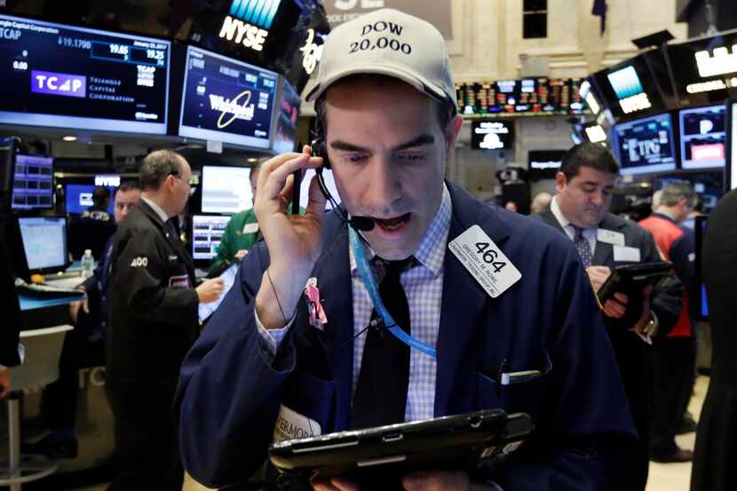 Trader Gregory Rowe wears a Dow 20,000 cap as he works on the floor of the New York Stock...