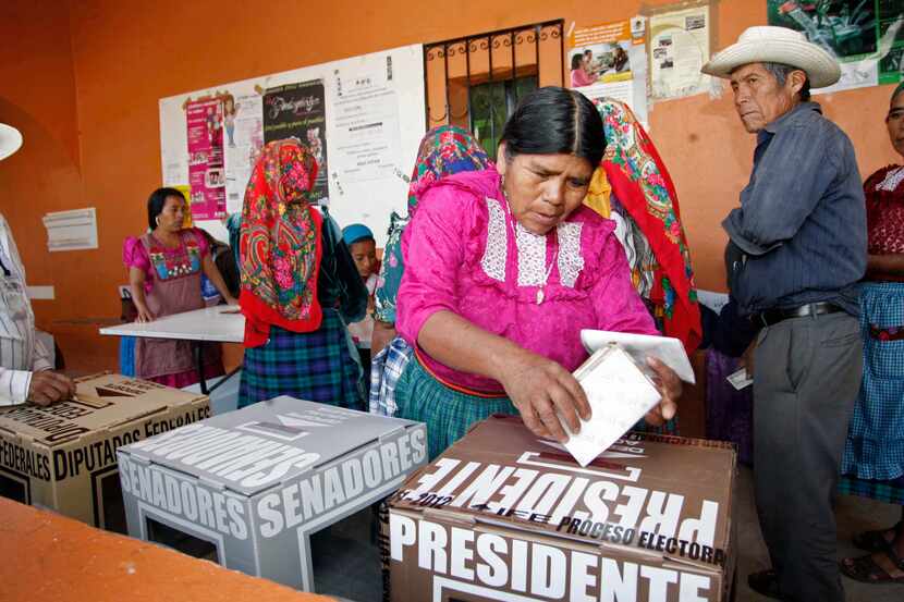 A woman casts her ballot at a polling station in Oaxaca, Mexico, Sunday, July 1, 2012....