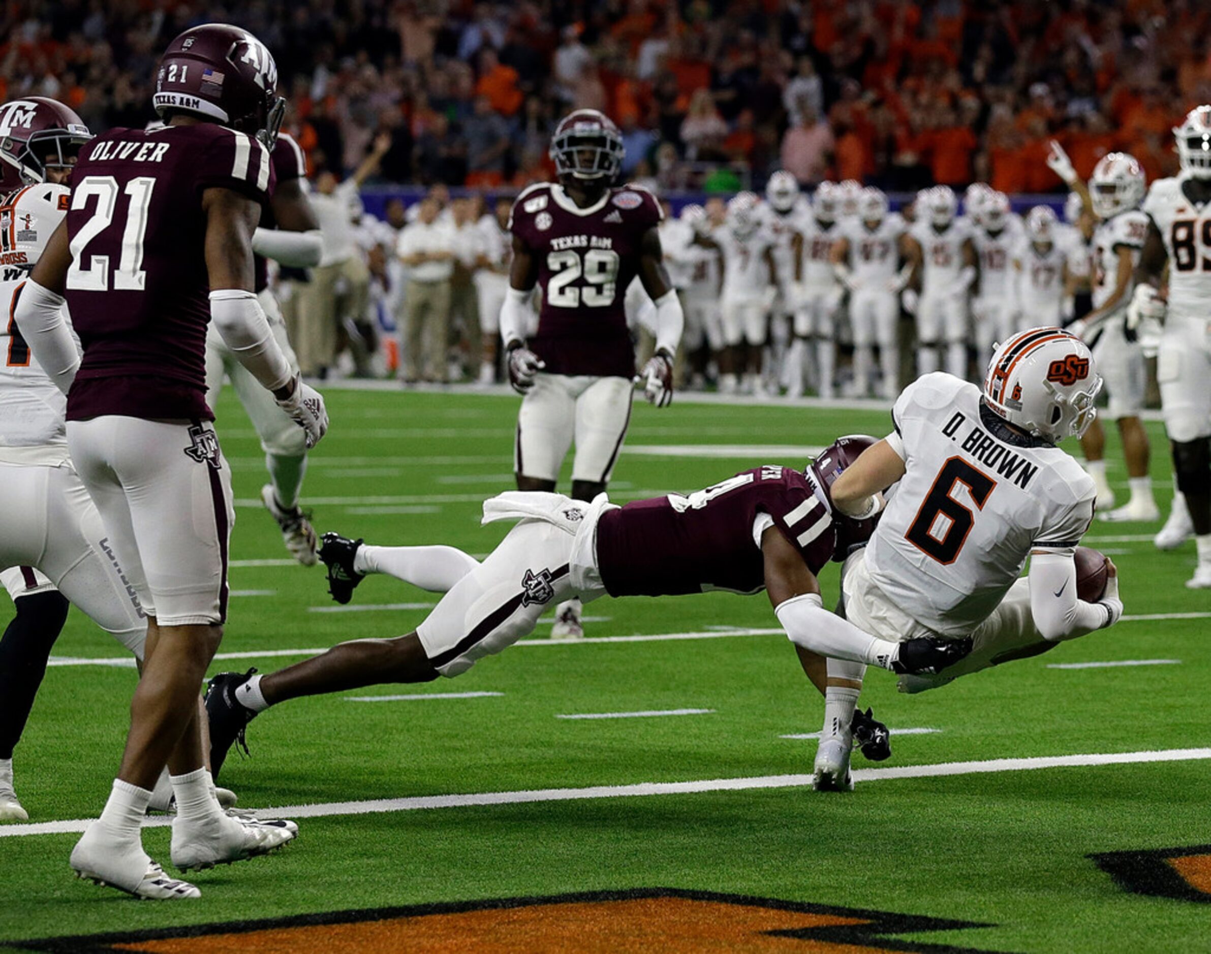 HOUSTON, TEXAS - DECEMBER 27: Dru Brown #6 of the Oklahoma State Cowboys scores on a nine...