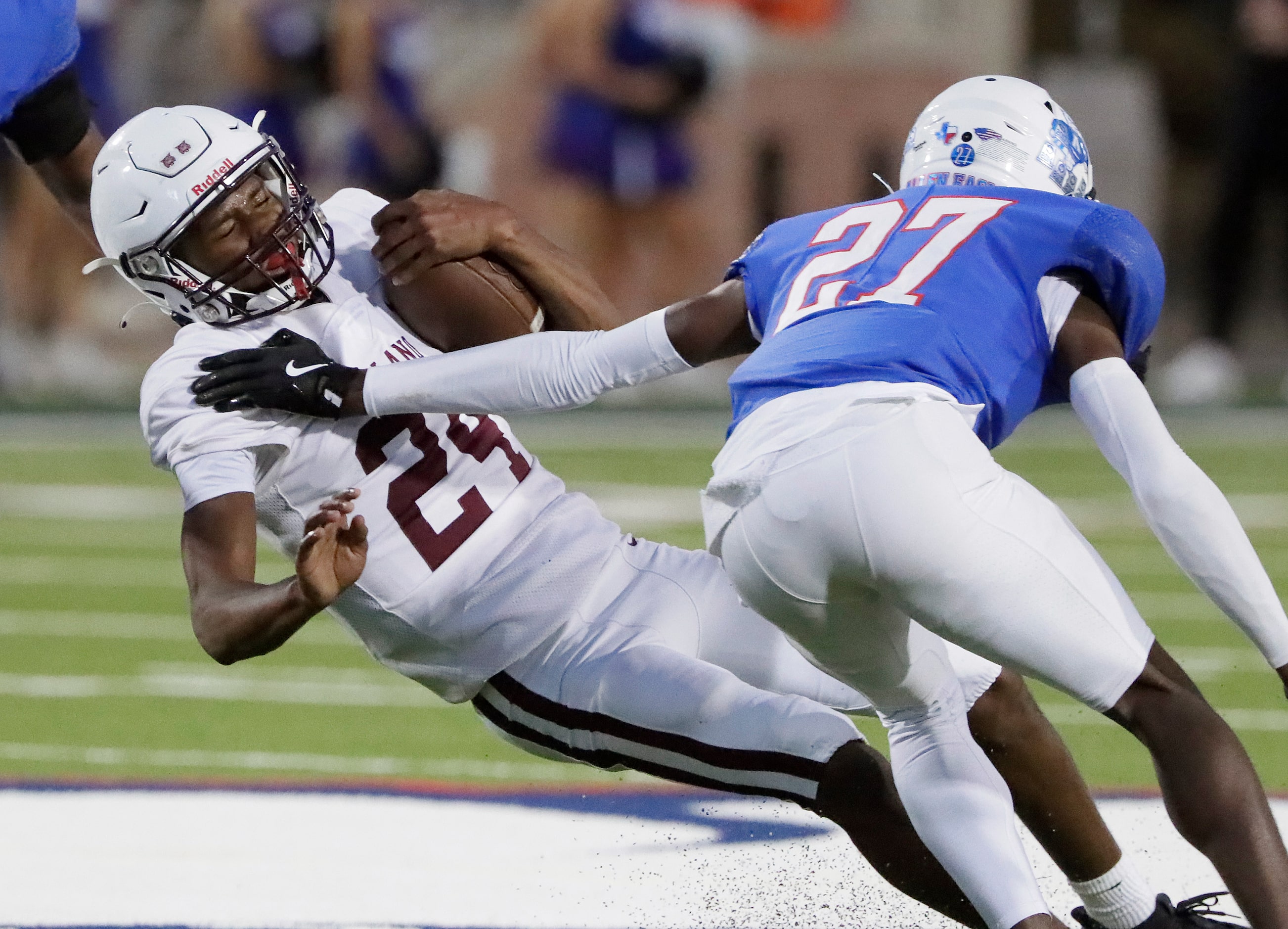 Plano High School quarterback Tyree Fisher (24) falls forward past Allen High School...