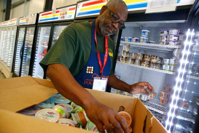 Volunteer Louis Lewis organizes yogurt at CitySquare Opportunity Center food pantry in...