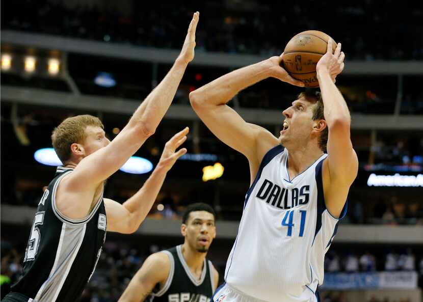 San Antonio Spurs' Matt Bonner, left, defends as Dallas Mavericks' Dirk Nowitzki attempts to...