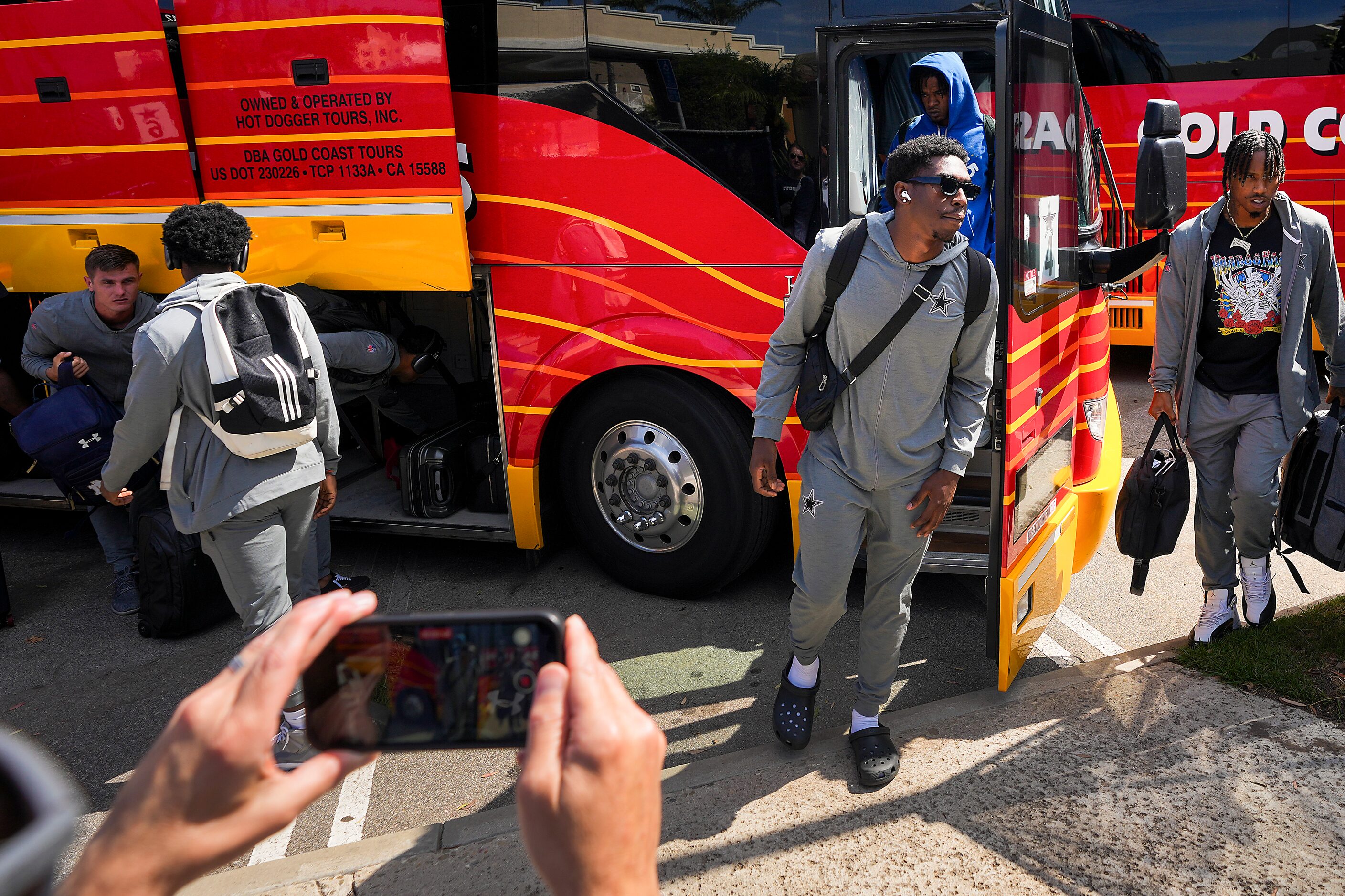 Dallas Cowboys players exit the team’s buses as they arrive for training camp on Monday,...