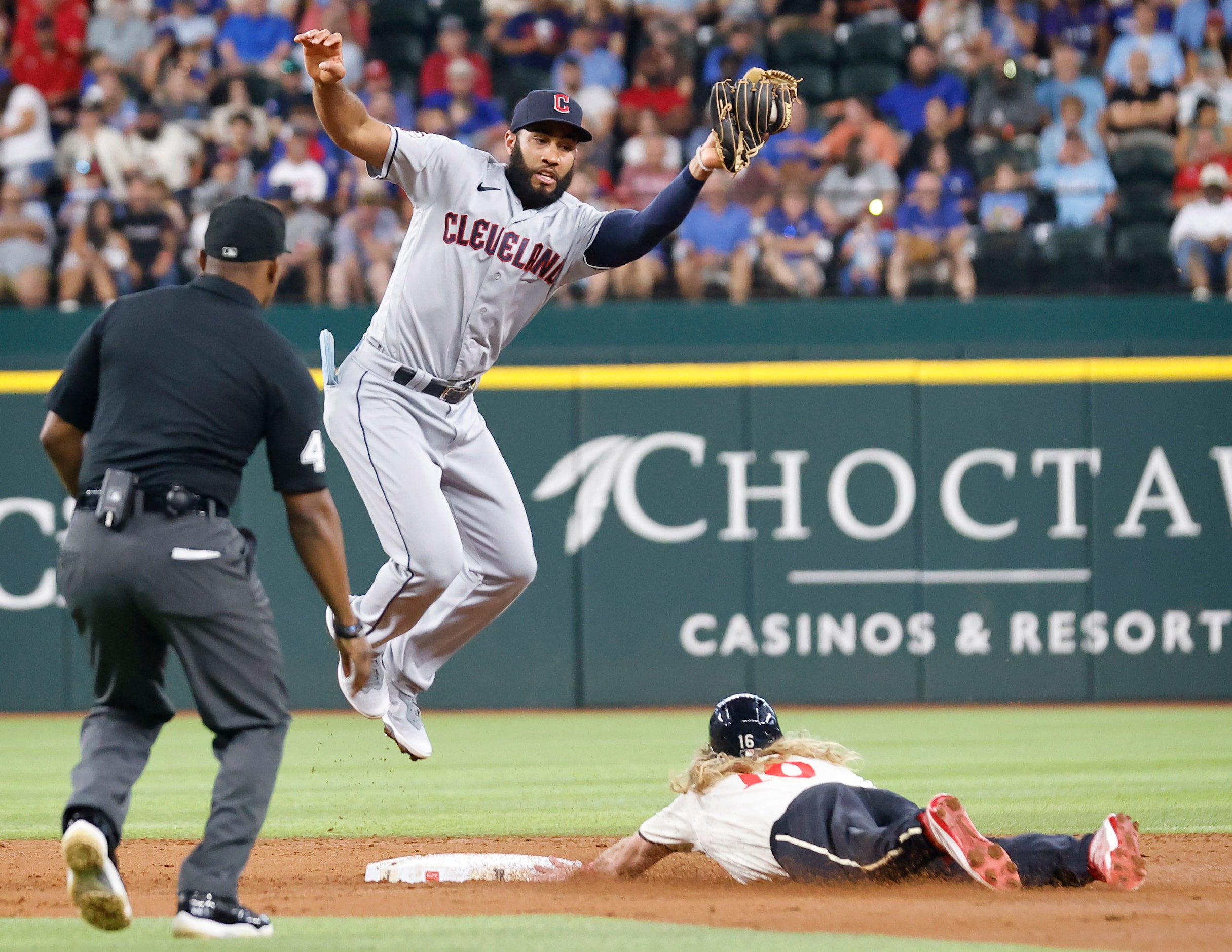 Cleveland Guardians shortstop Amed Rosario (1) goes high to get the throw down as Texas...