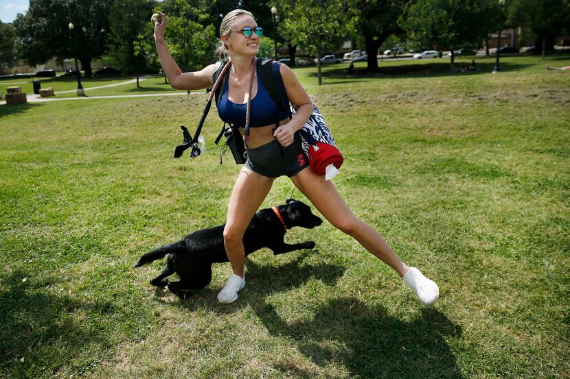 Amanda Calhoun of Dallas throws a tennis ball to her black lab KC at Cole Park on Friday. ...