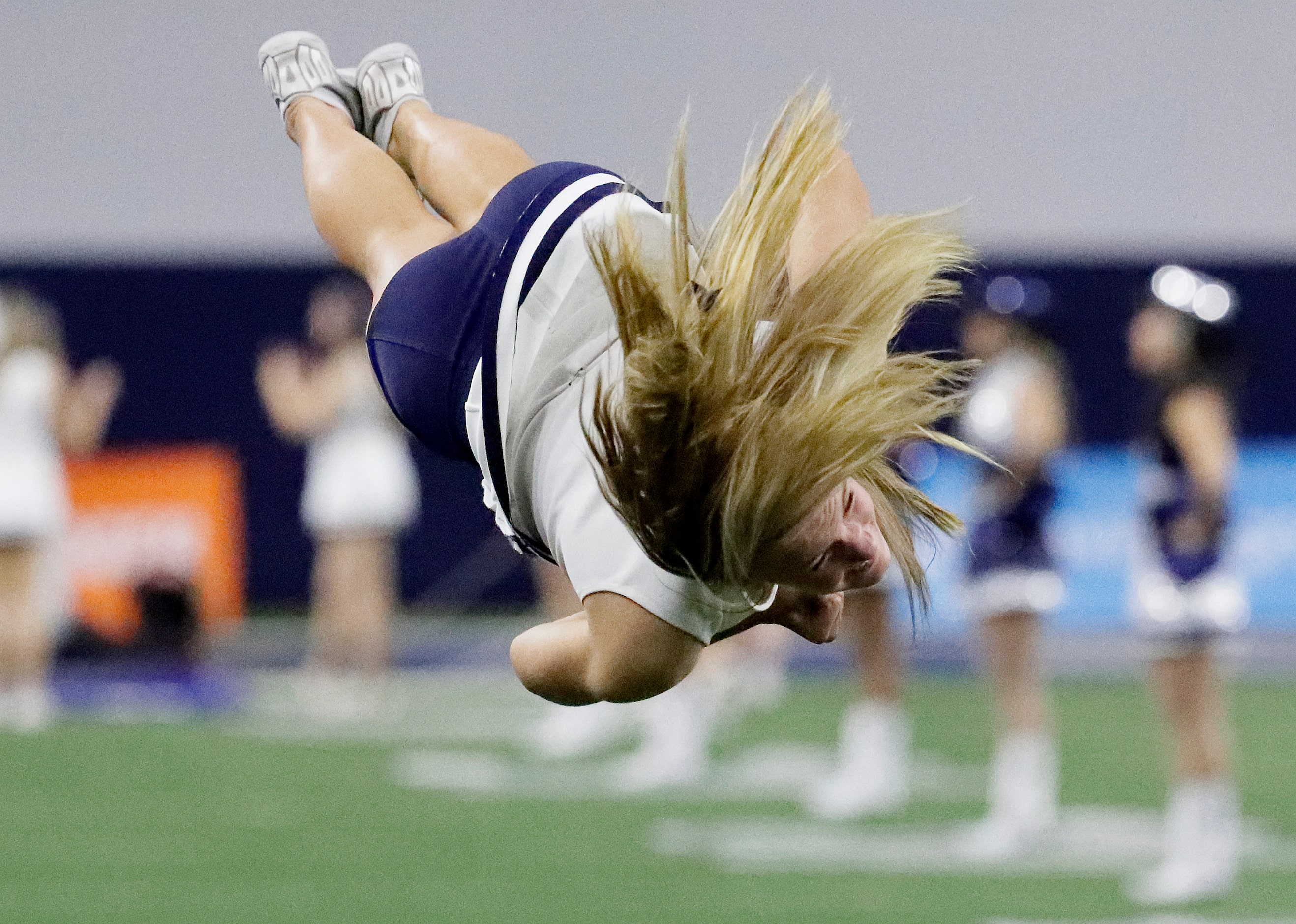 Lone Star High School freshman cheerleader Chloe Cagney, 14, warms up performing back flips...