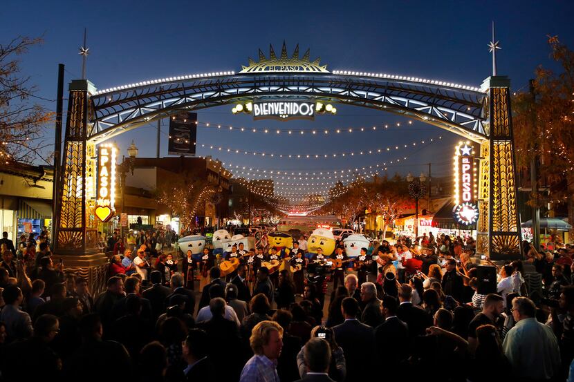 People gathered around a gateway arch to celebrate the lighting of South El Paso Street...