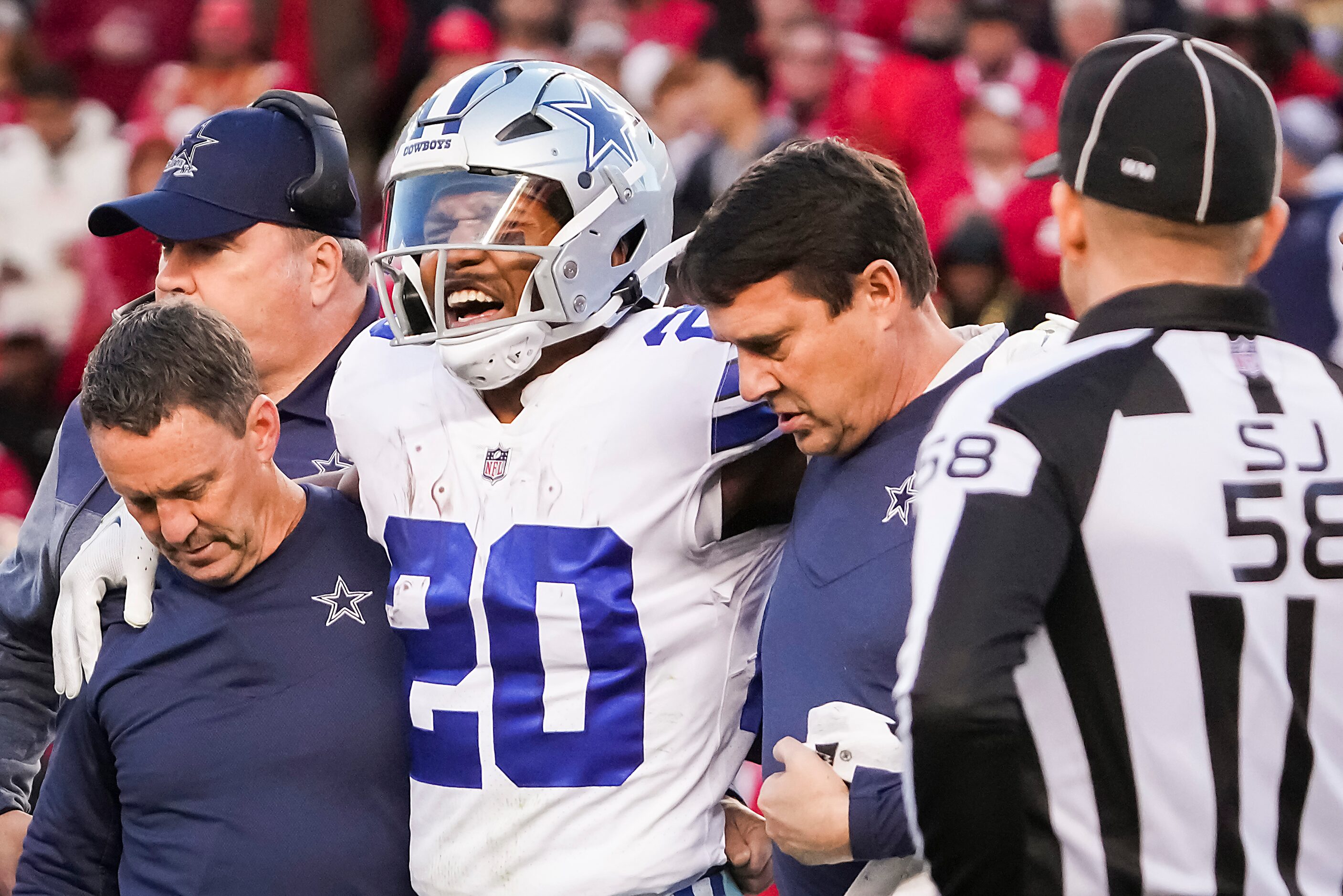 Dallas Cowboys running back Tony Pollard (20) grimaces as he leaves the field after being...