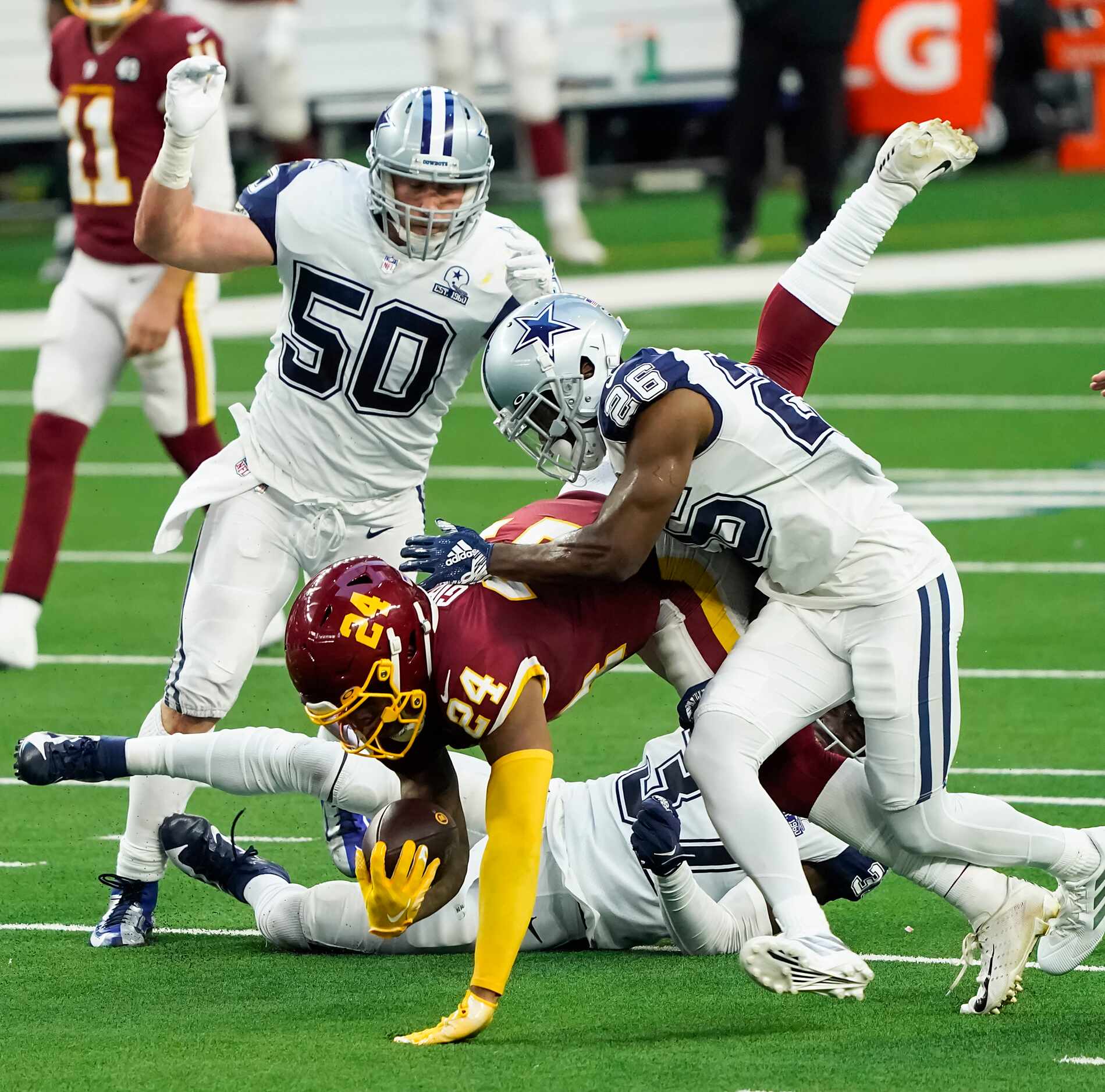 Washington Football Team running back Antonio Gibson (24) is upended by Dallas Cowboys...