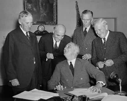 President Franklin D. Roosevelt signs America's first peacetime draft law in the Cabinet...