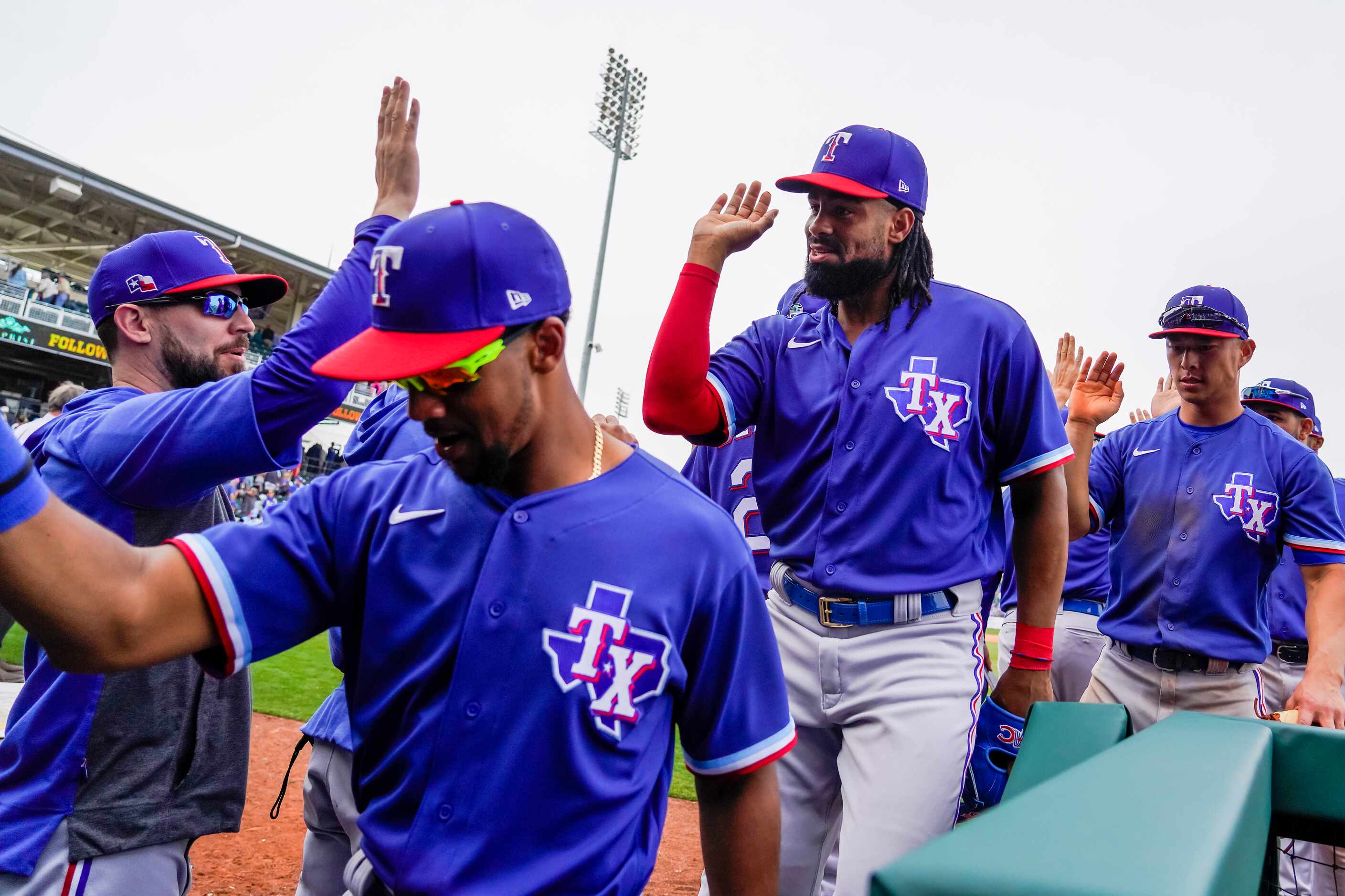 Texas Rangers outfielder Henry Ramos (center) high fives teammates after a 5-4 win over the...