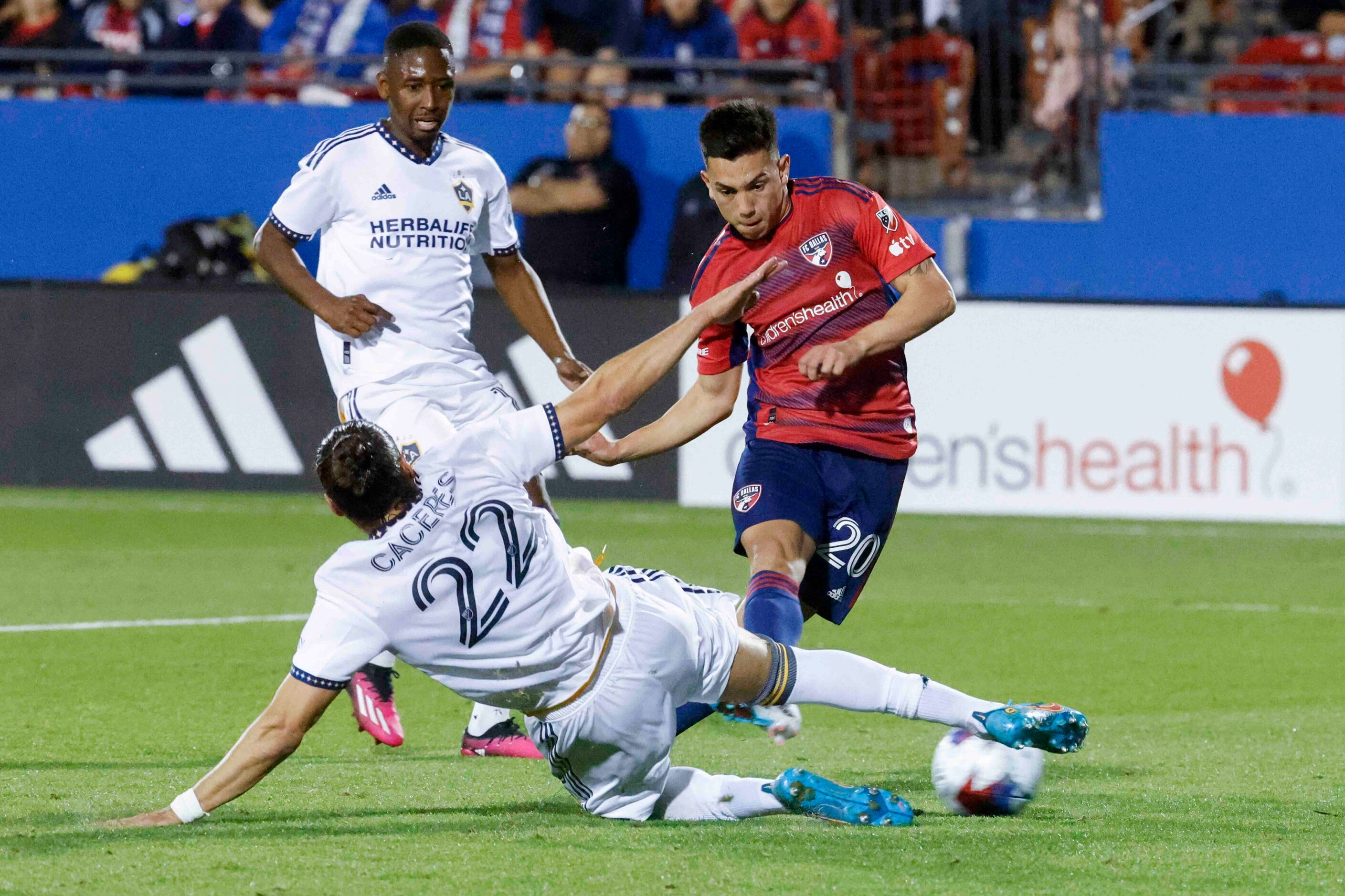 FC Dallas forward Alan Velasco (right) scores a goal past Los Angeles Galaxy defender Martín...