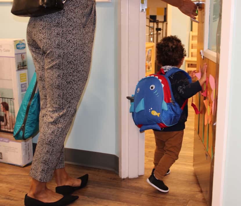 A young boy enters the toddler room with his mother at the KinderCare Child Development...