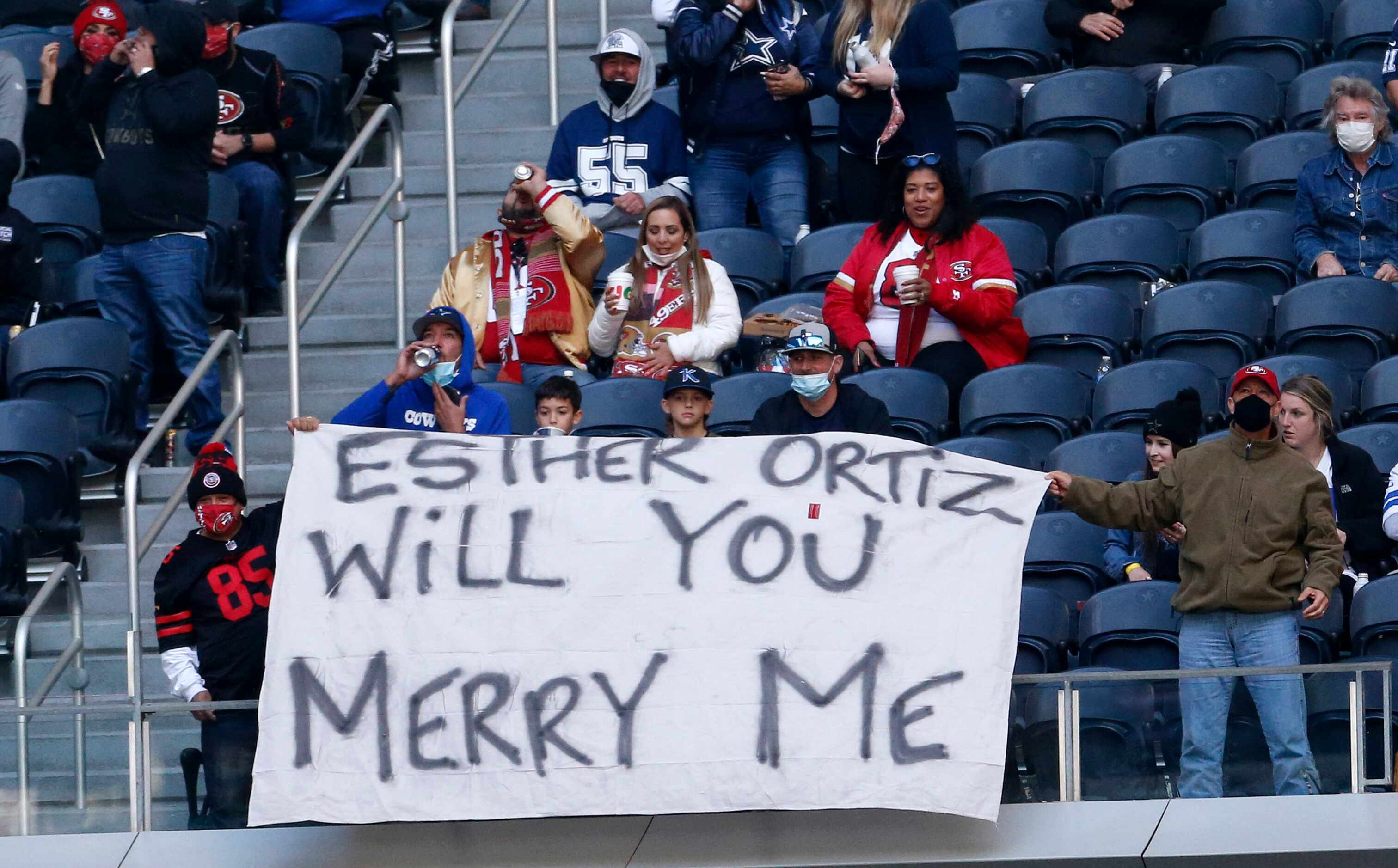 Fans hold up a sign for Esther Ortiz for possible proposal or holiday style proposal during...