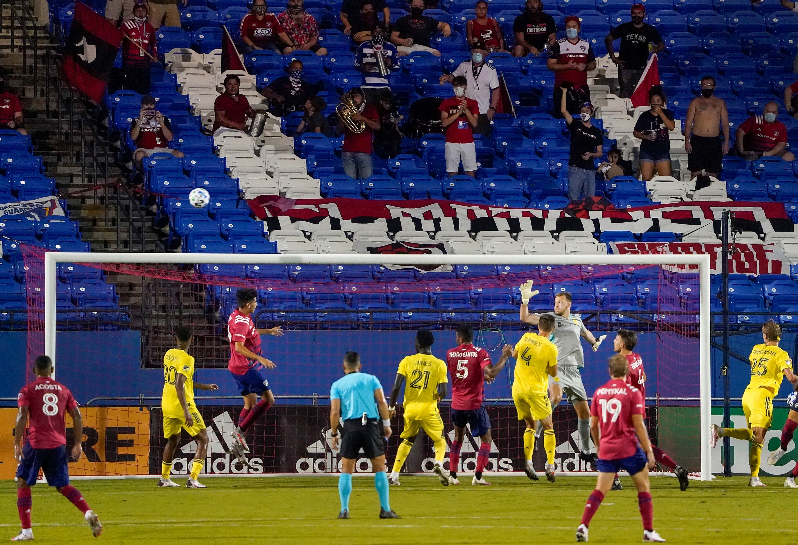 Socially distant FC Dallas supporters watch a corner kick sail over the head of forward...