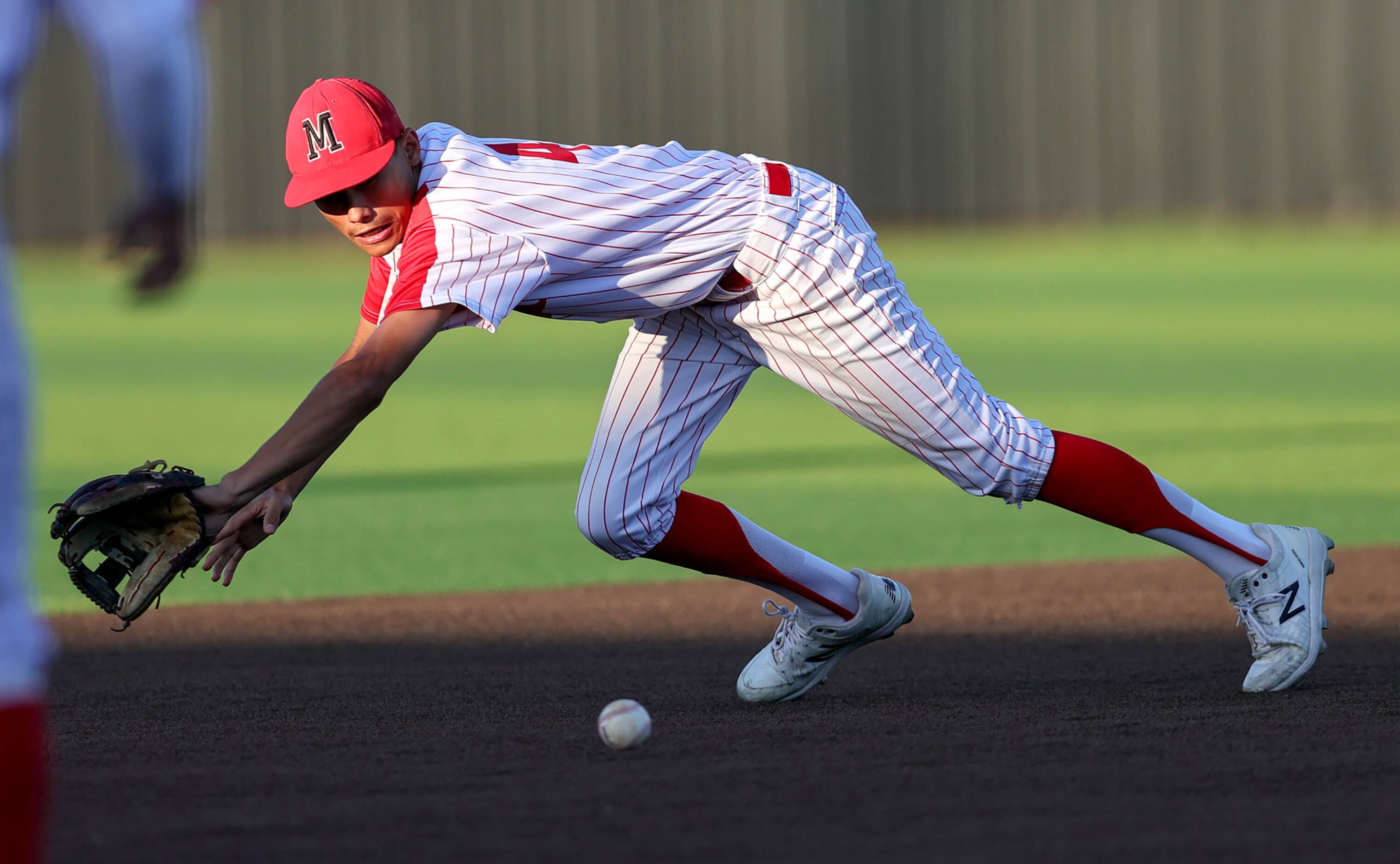 Flower Mound Marcus shortstop Cam Mitchell tries to come up with a groundball against Keller...