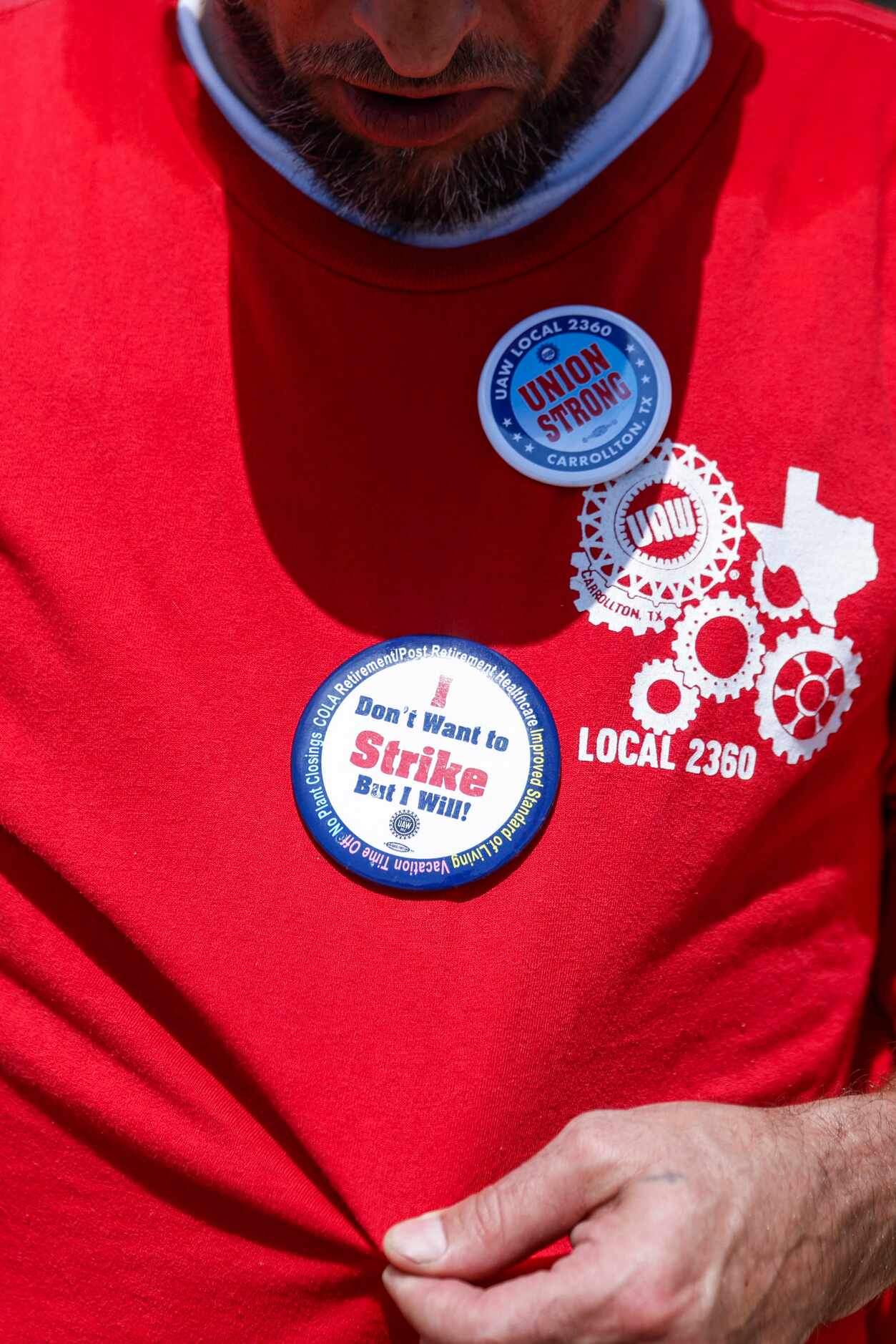 Co-chair off community service committee of UAW local 2360, Phillip Laws, shows his badges...