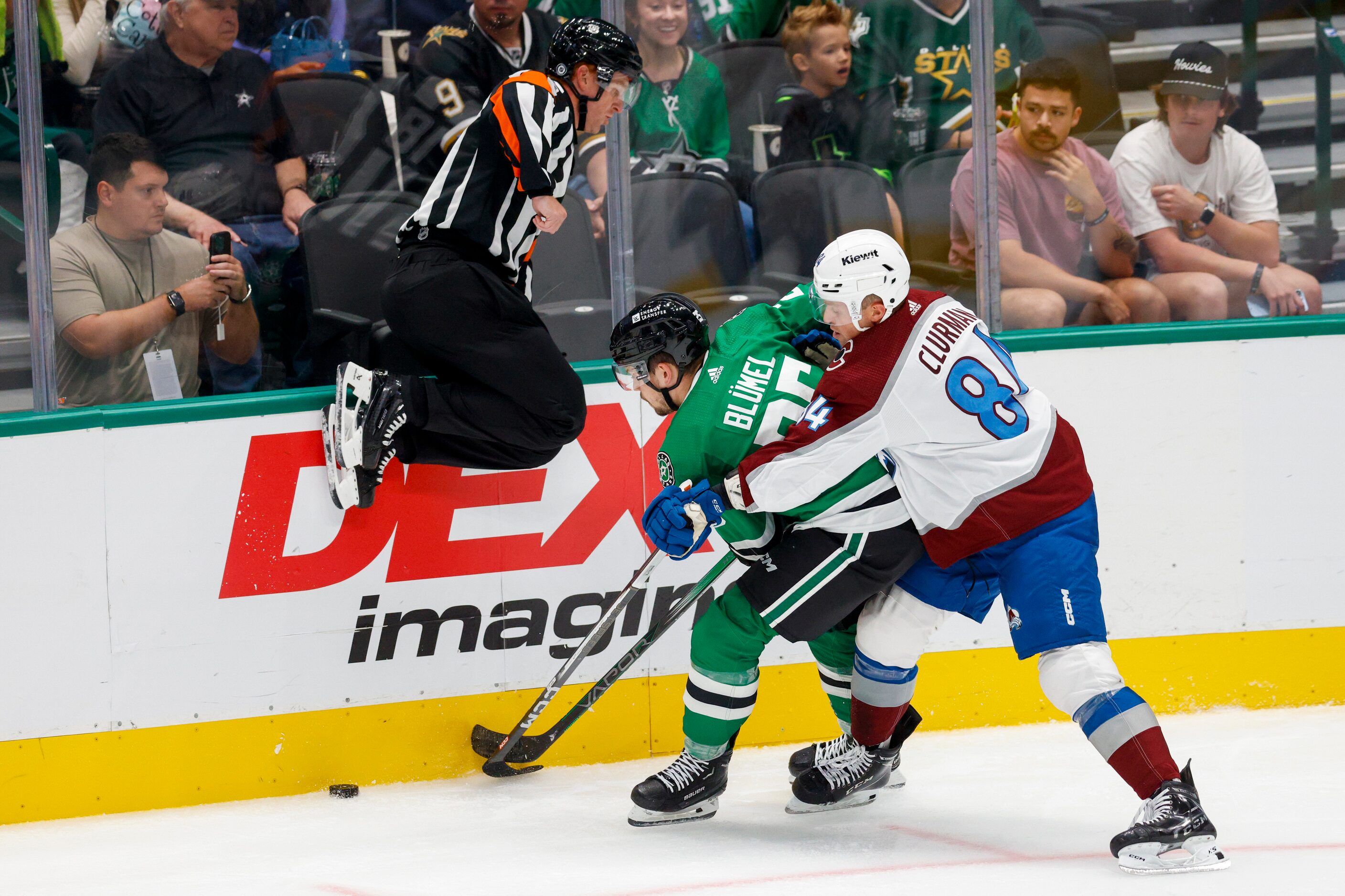 An official jumps out of the way as Dallas Stars right wing Matej Blumel (25) and Colorado...