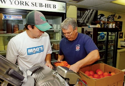 This 2011 file photo shows New York Sub Hub then-owner Ken Christiansen (right) and his son,...