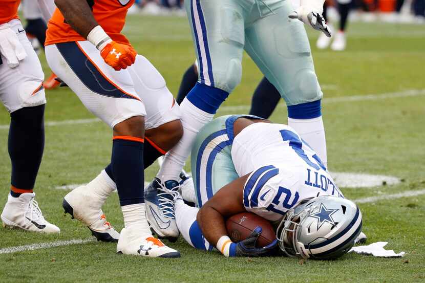 Dallas Cowboys running back Ezekiel Elliott (21) is lays o the field after being tackled by...