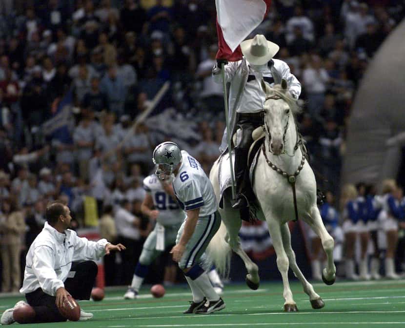 Cowboy's Texas flag bearing horse takes out kicker #6 Tim Seder during pregame warmups of...