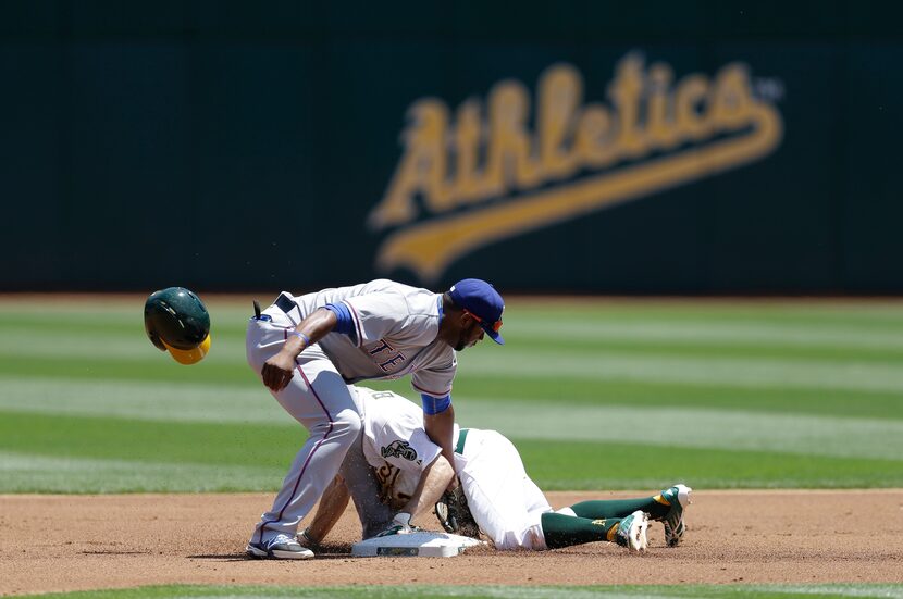 Texas Rangers' Hanser Alberto, left, tags as Oakland Athletics' Billy Burns steals second...