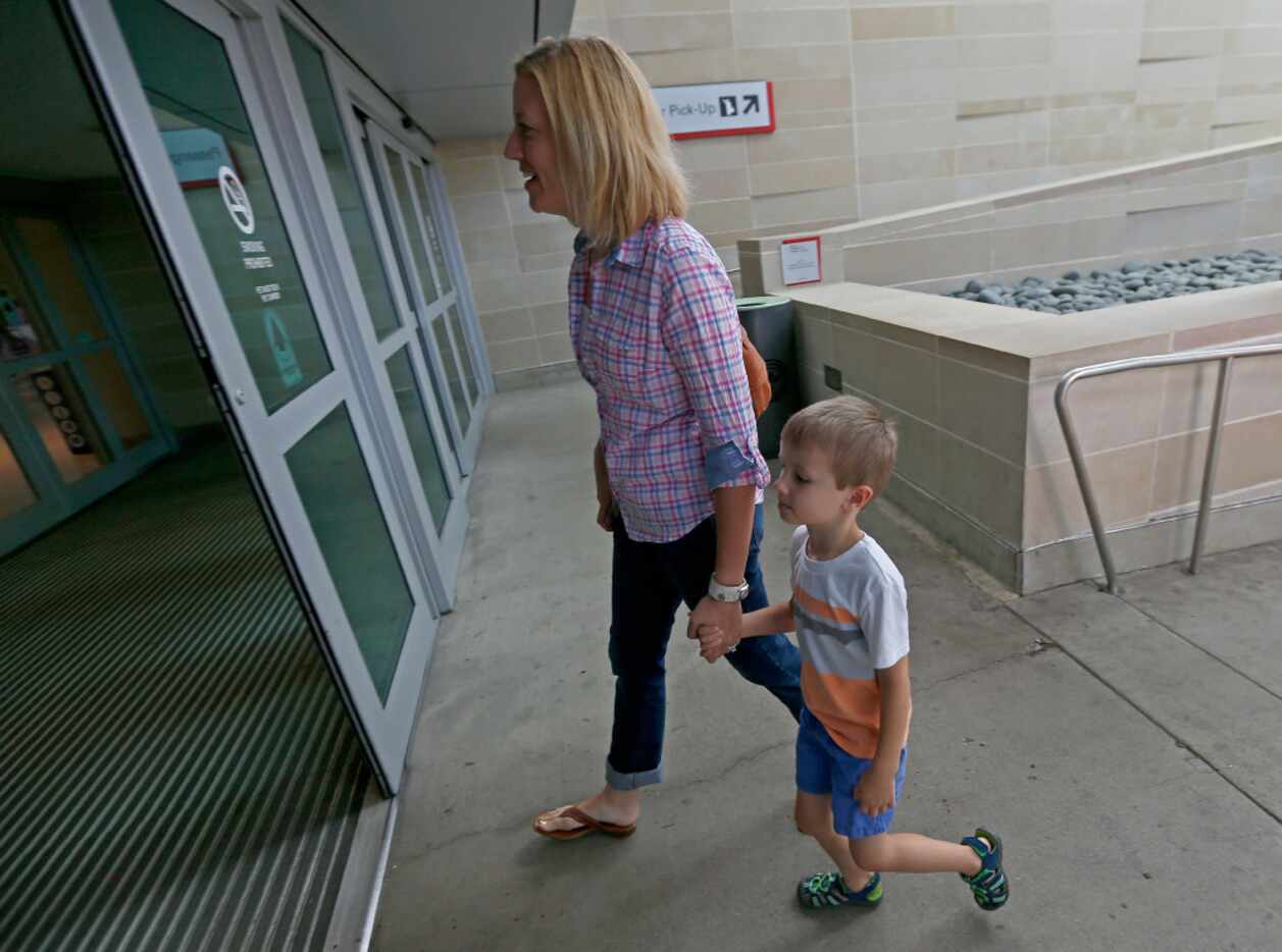 Luke Swofford (right), 4, and his mother Nikki Swofford enter Dallas Love Field Airport to...