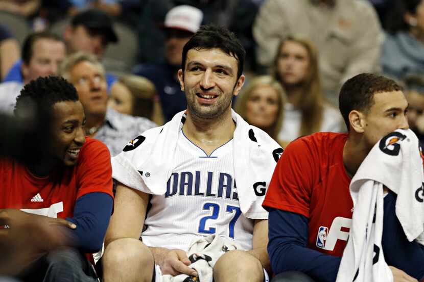 Dallas Mavericks center Zaza Pachulia (center) is all smiles on the bench after his...
