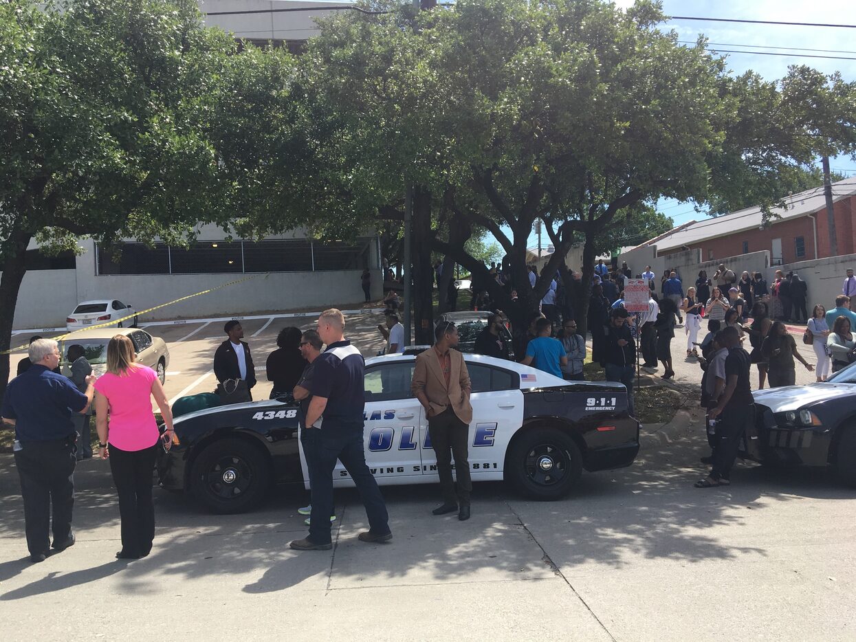 Workers stand outside at Lake Highlands office building where a shooting was reported Monday...