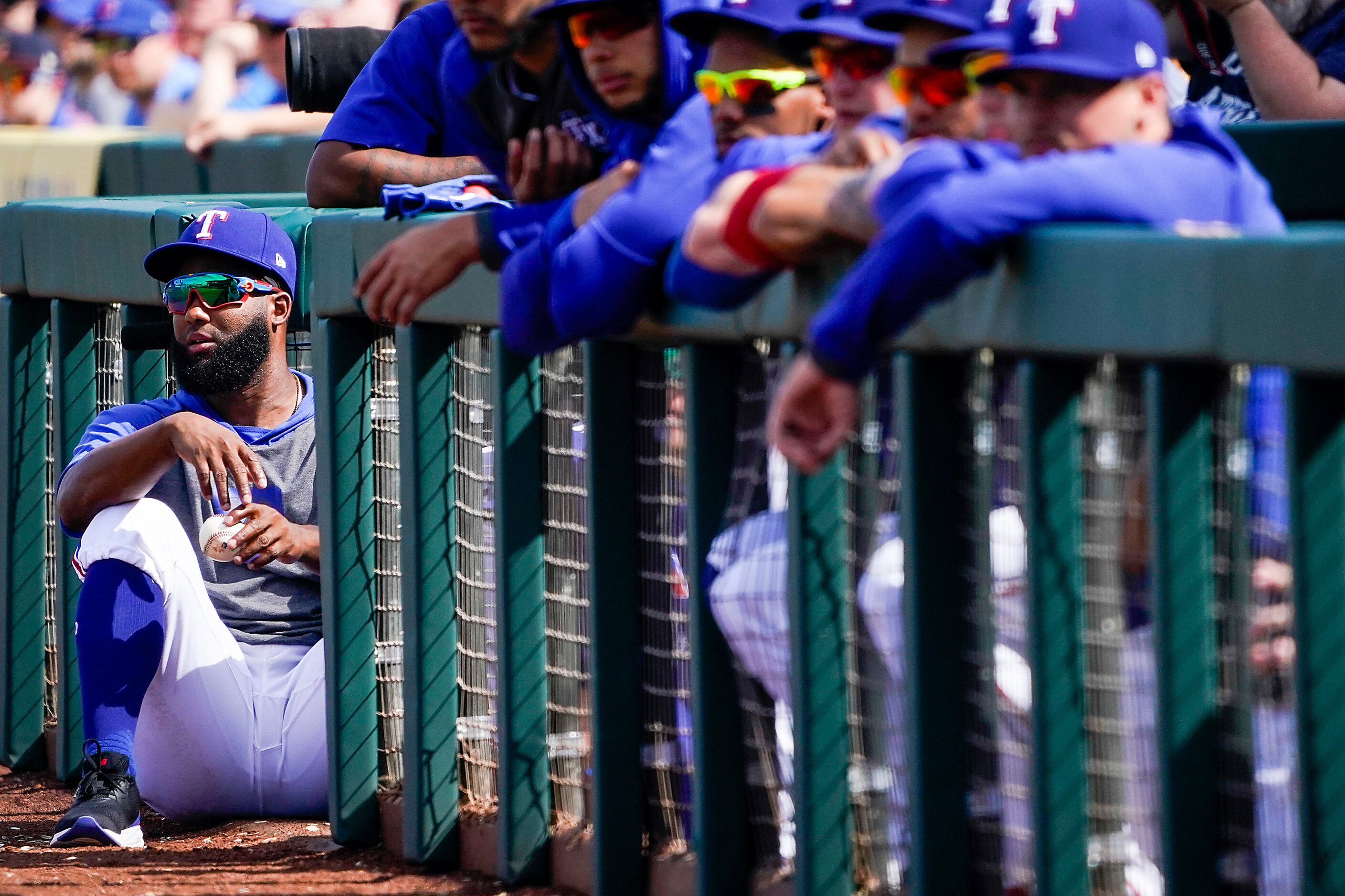 Texas Rangers outfielder Danny Santana takes in the action from the top of the dugout steps...