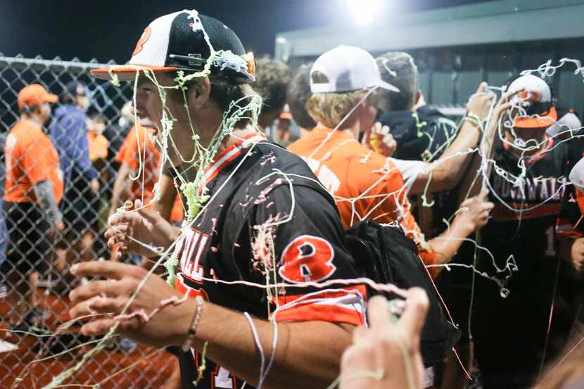 Rockwallâs Paden Adams (7) gets spayed with confetti following the teamâs 11-1 victory...