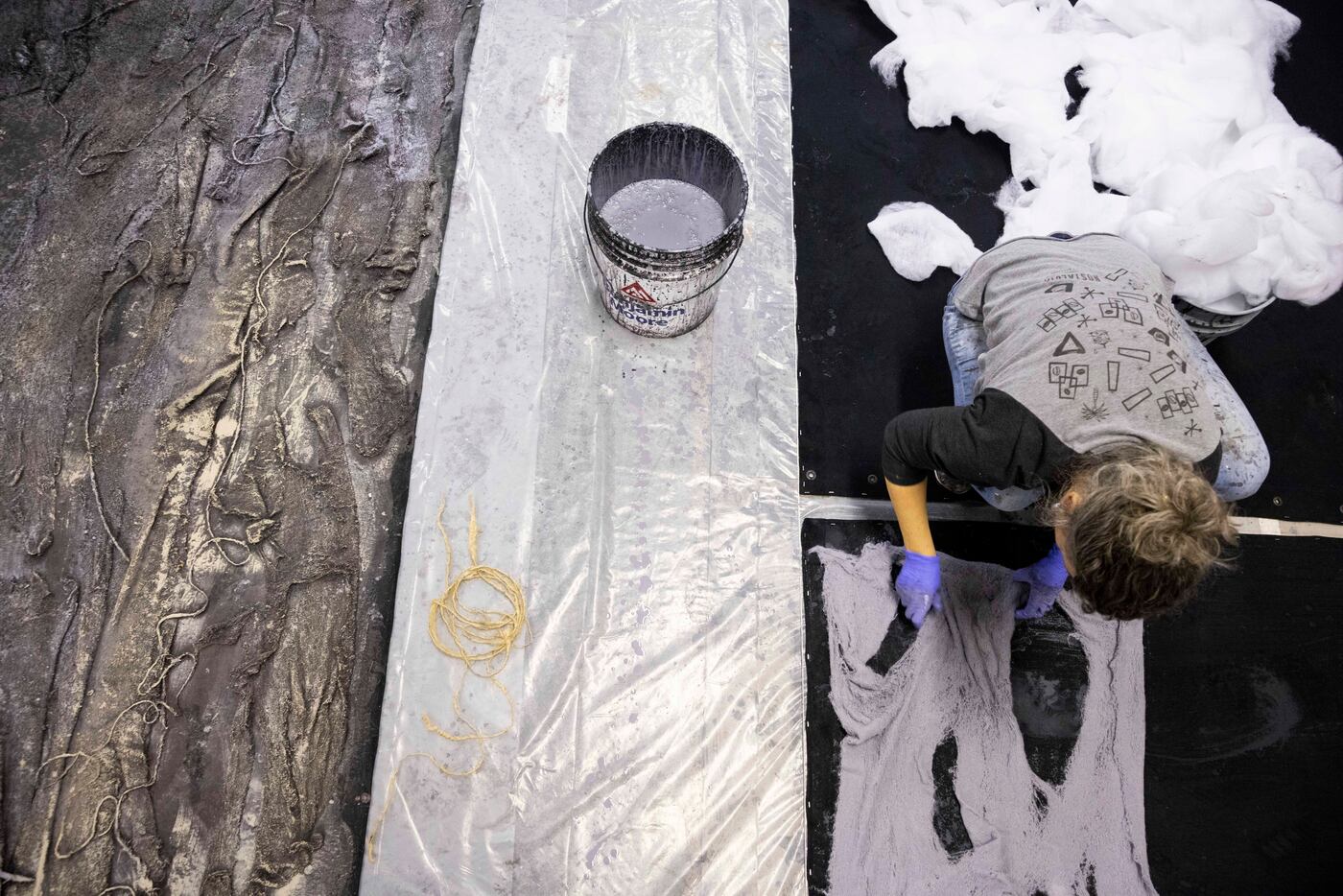 Scenic artist Marlowe Hermanovski uses material such as erosion cloth and string to add...