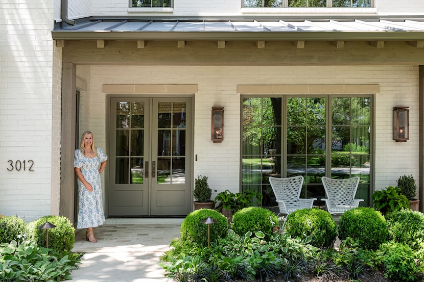 Woman stands in front of elegant home