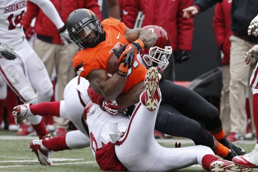 Oklahoma State running back Jeremy Smith (31) is brought down by Oklahoma defensive back...