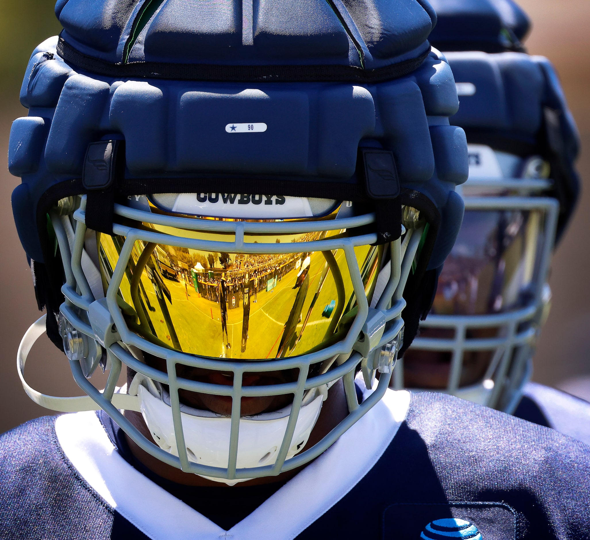 Training camp practice is reflected in the visor of Dallas Cowboys defensive end DeMarcus...