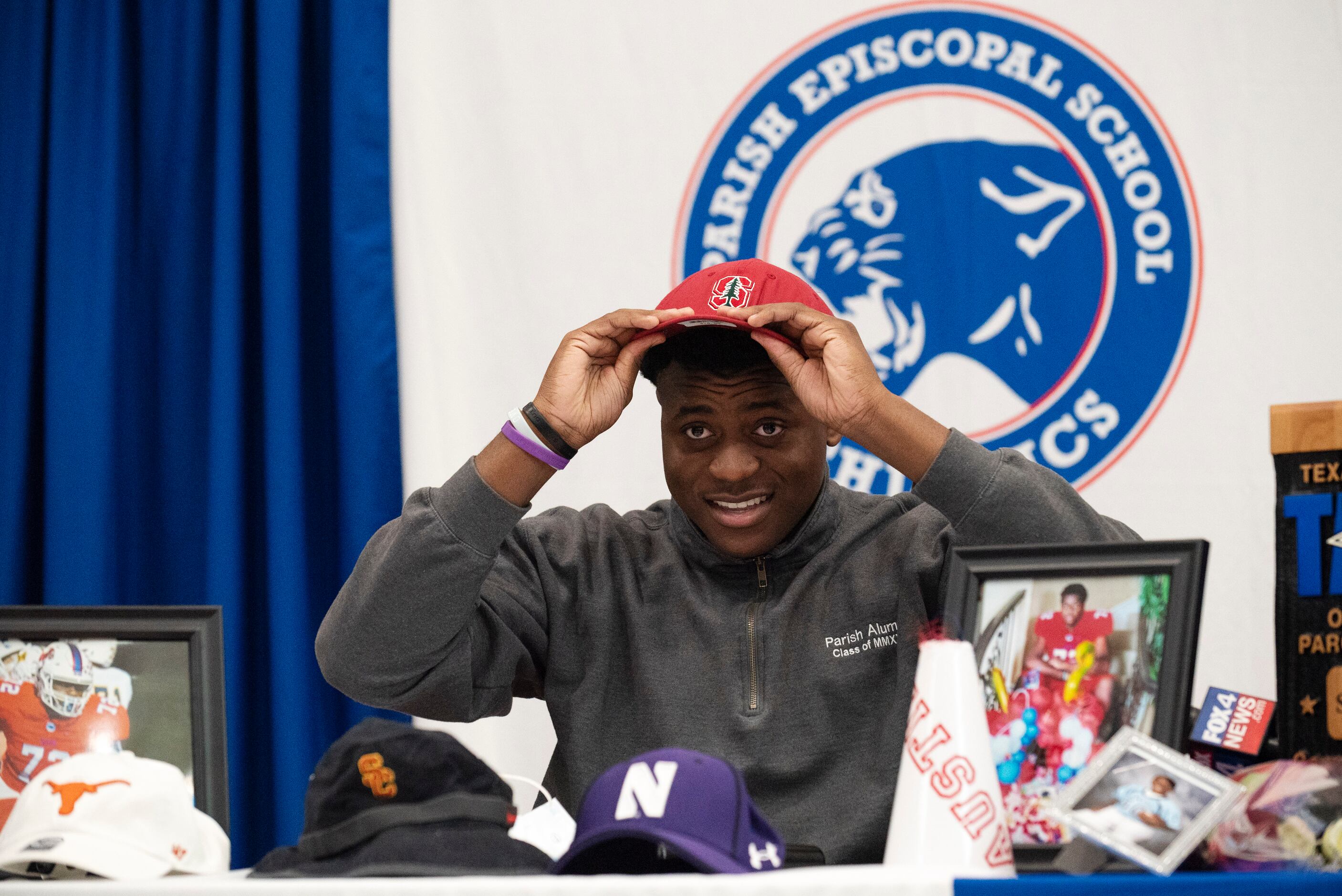 Senior Austin Uke fits a Stanford University cap on his head after revealing he plans to...