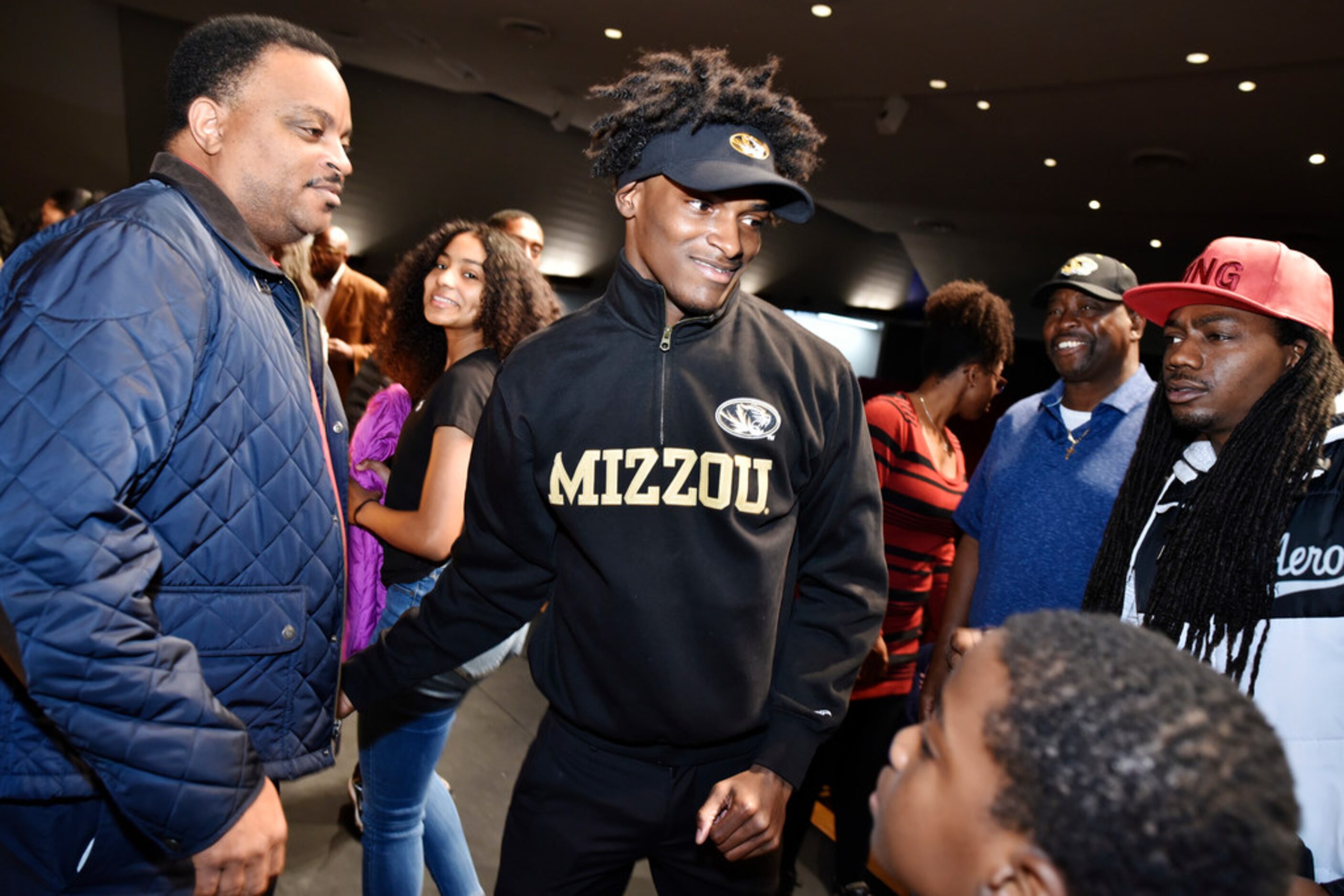 Duncanville cornerback Ennis Rakestraw, Jr., center, is congratulated by friends and family...