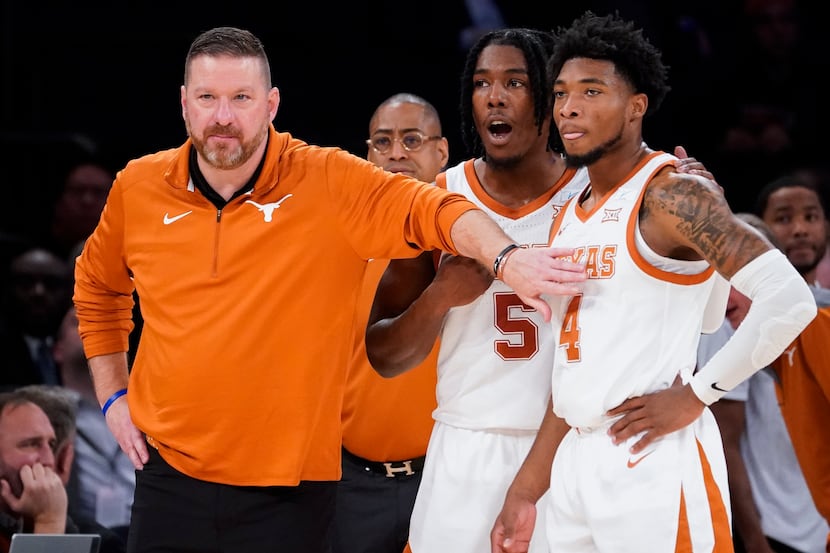 Texas' head coach Chris Beard, left, meets with Tyrese Hunter (4) and Marcus Carr (5) at the...
