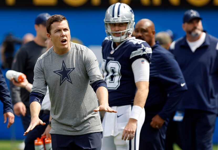 Dallas Cowboys offensive coordinator Kellen Moore motion to his players during pregame...