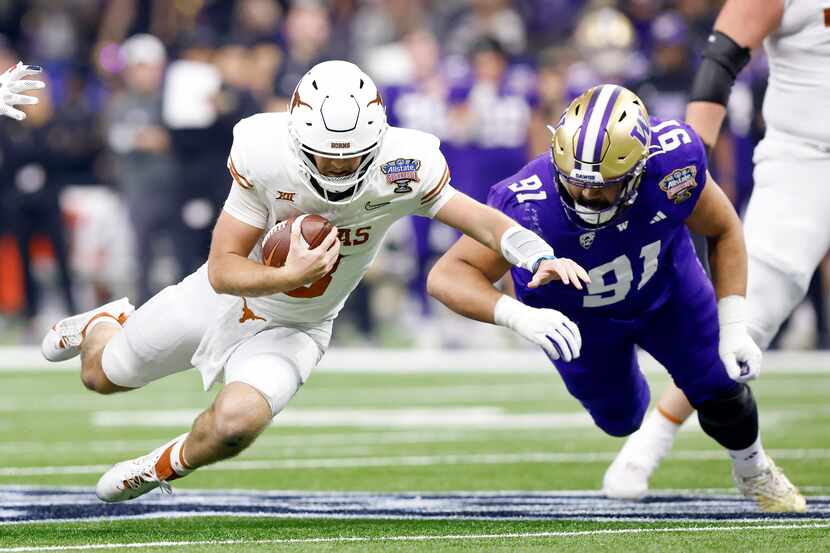 Texas Longhorns quarterback Quinn Ewers (3) dives for extra yards as Washington Huskies...