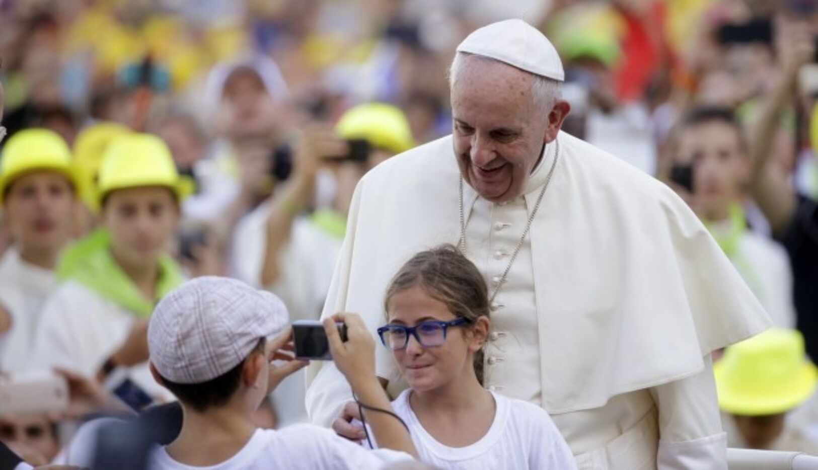 El papa Francisco posa con una niña para una foto en la plaza de San Pedro. El Pontífice...