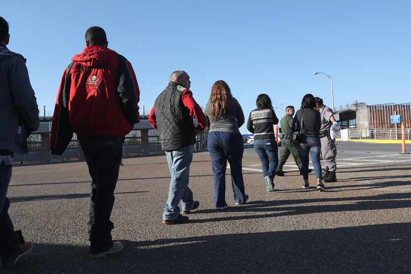 Un grupo de migrantes son deportados por medio de un puente internacionalen Hidalgo Texas....