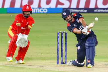 United States' Andries Gous (right) hits a six as Canda’s wicket keeper Shreyas Movva...