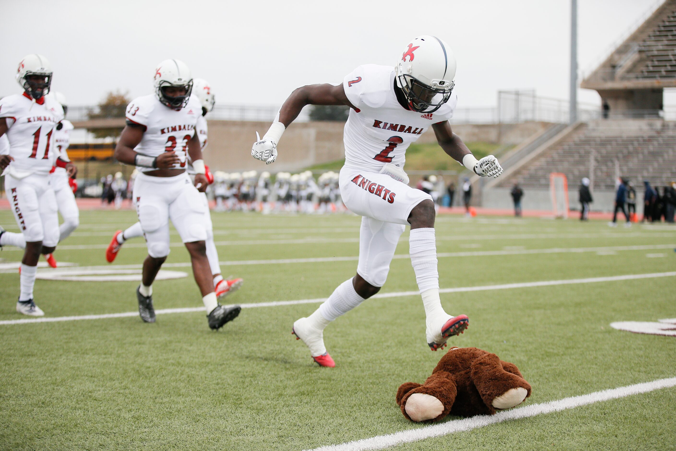 Kimball junior wide receiver Kyron Henderson (2) stomps on a stuffed bear, South Oak Cliff’s...