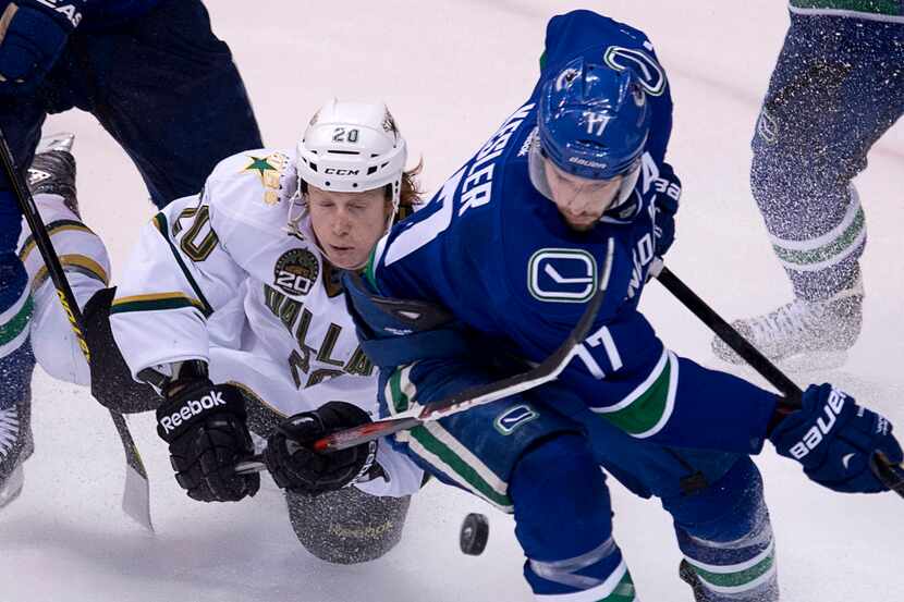 Dallas Stars center Cody Eakin (20) fights for control of the puck with Vancouver Canucks...