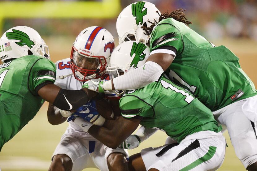 North Texas senior defensive back James Gray (21), senior defensive back Chad Davis (16) and...