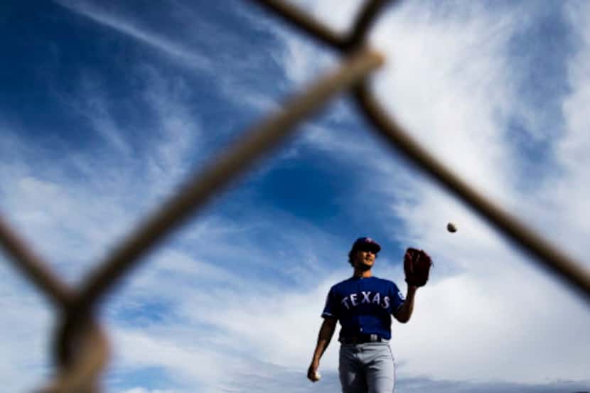 Texas Rangers starting pitcher Yu Darvish (11) lifts his glove to catch a pass as he throws...