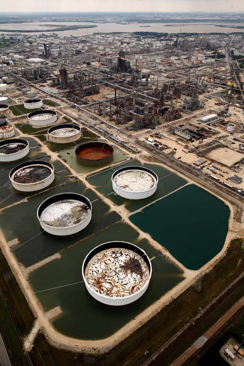 Large storage tanks situated in retention ponds are surrounded by rainwater left behind by...